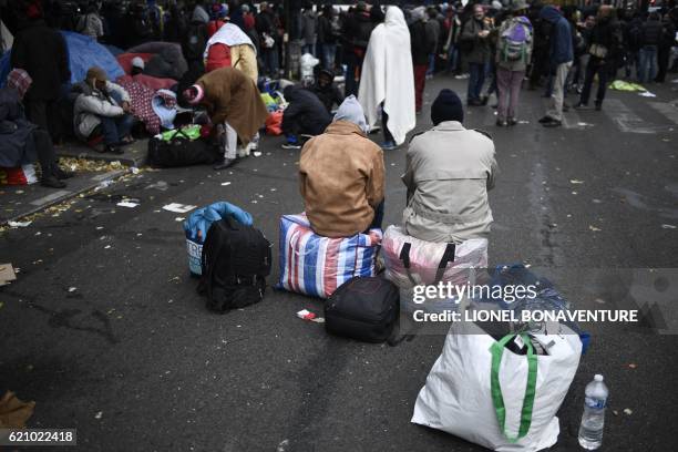 Migrant wait during the evacuation of a makeshift camp near Stalingrad metro station in Paris on November 4 one of several camps sprouting up around...