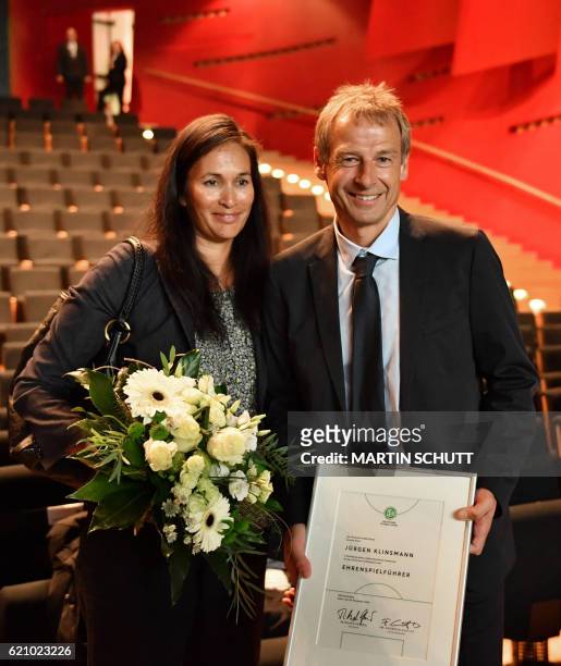 Former German national football team coach Juergen Klinsmann poses with his wife Debbie after he was named honorary captain of the German national...