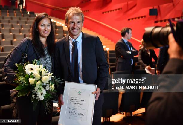 Former German national football team coach Juergen Klinsmann poses with his wife Debbie after he was named honorary captain of the German national...