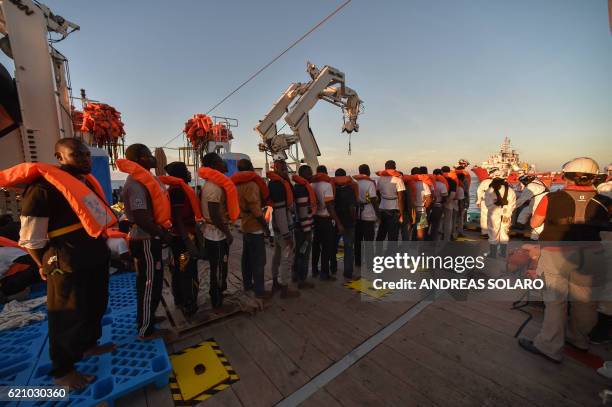 Migrants and refugees wait to be trasferred from the Topaz Responder ship run by Maltese NGO "Moas" and the Italian Red Cross to the Vos Hestia ship...