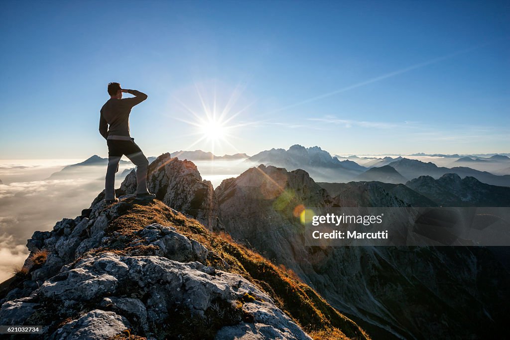 Climber standing on a mountain peak