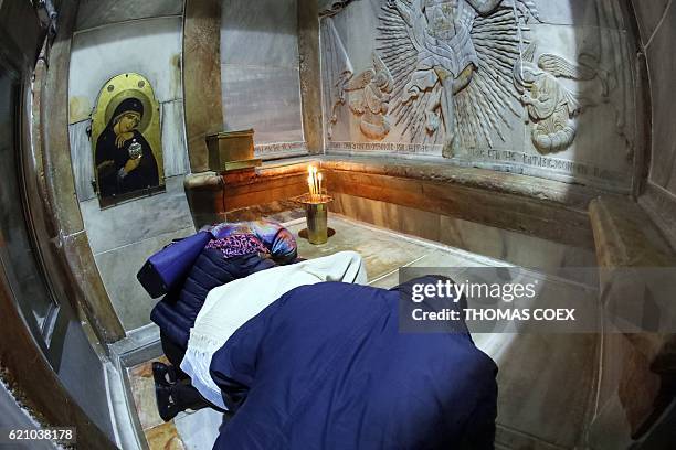 Christian worshippers pray inside the Edicule over the Tomb of Jesus on November 4, 2016 at the Church of the Holy Sepulchre in Jerusalems Old City....