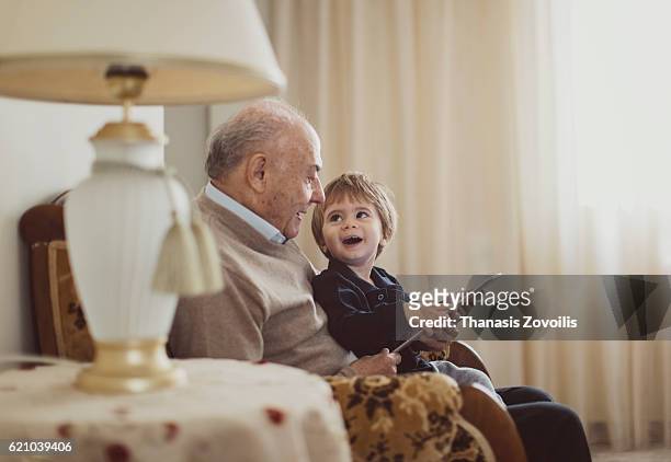 grandfather with his grandson using a digital tablet - grandfather stock pictures, royalty-free photos & images