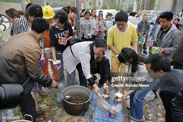 China - Survivors fetch hot water for cup noodles from relief supplies in Lushan county in Ya'an, the southwestern Chinese province of Sichuan, on...