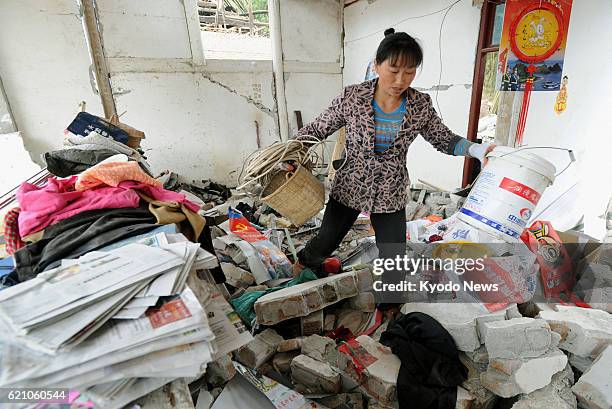 China - A woman take properties from her damaged home in the Lushan county area of Ya'an in the southwestern Chinese province of Sichuan, on April 22...