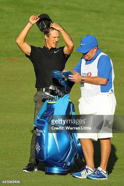 Thorbjorn Olesen of Denmark waits on the 18th hole with his caddie Dominic Bott during day two of the Turkish Airlines Open at the Regnum Carya Golf...