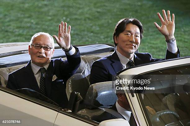 Japan - Former professional baseball players Hideki Matsui and Shigeo Nagashima, Matsui's first pro skipper, wave at fans aboard a car making a...