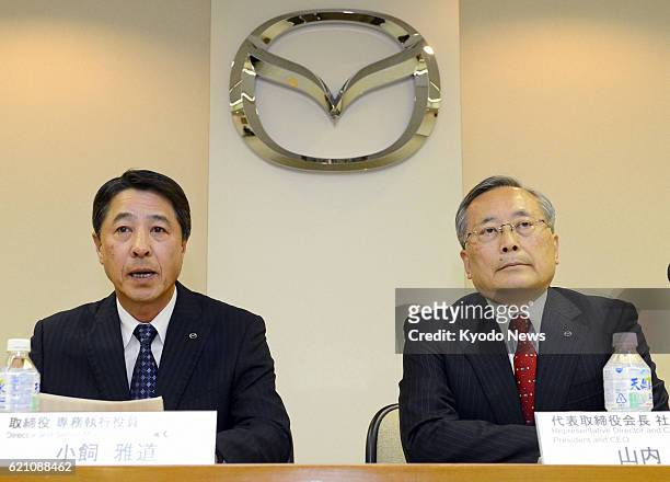 Japan - Masamichi Kogai , senior managing executive officer of Mazda Motor Corp., and Takashi Yamanouchi, chairman and president of the company, hold...
