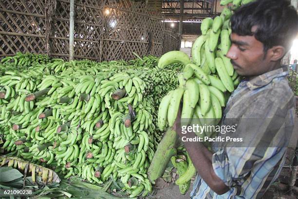 Laborers unload bananas from truck ahead of Hindu Vedic festival dedicated to the Hindu Sun God "Chhath Puja" at wholesale market Mundera Mandi.