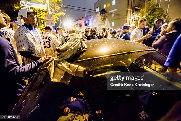 Chicago Cubs fans surround a squad car while celebrating outside Wrigley Field after the Cubs defeated the Cleveland Indians in game seven of the...