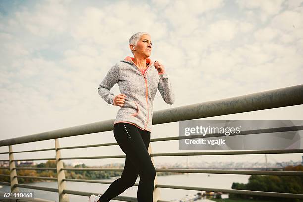 mature woman running the city - serbia bridge stock pictures, royalty-free photos & images