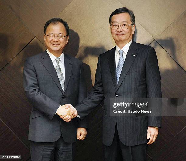 Japan - Sharp Corp. President Takashi Okuda and Executive Vice President Kozo Takahashi shake hands during a press conference in Tokyo on May 14,...