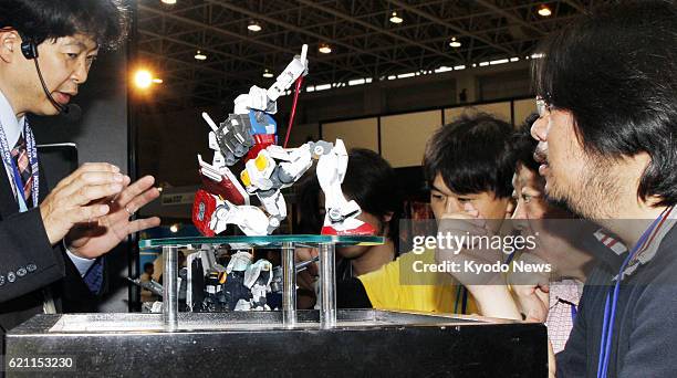 Japan - Visitors view new plastic models from the Mobile Suit Gundam robot animation series at the Shizuoka Hobby Show 2013, a major toy exhibition...