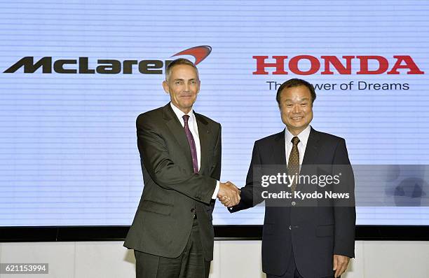 Japan - Martin Whitmarsh , chief executive officer of McLaren Group Ltd., and Honda Motor Co. President Takanobu Ito shake hands at a press...