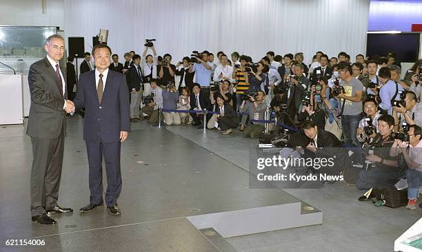 Japan - Martin Whitmarsh , chief executive officer of McLaren Group Ltd., and Honda Motor Co. President Takanobu Ito shake hands before the media at...