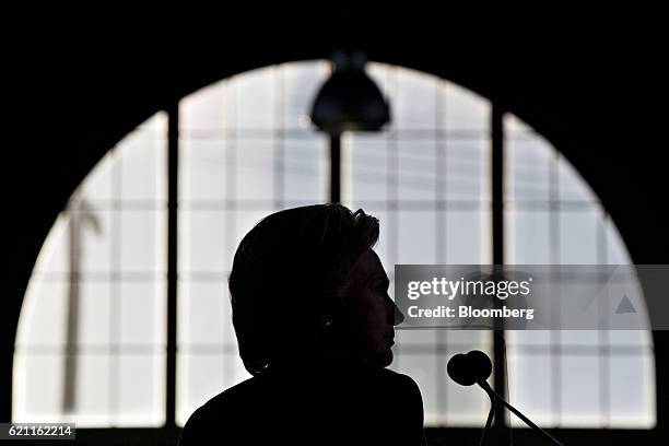 The silhouette of Hillary Clinton, 2016 Democratic presidential nominee, is seen during a campaign event in Detroit, Michigan, U.S., on Friday, Nov....