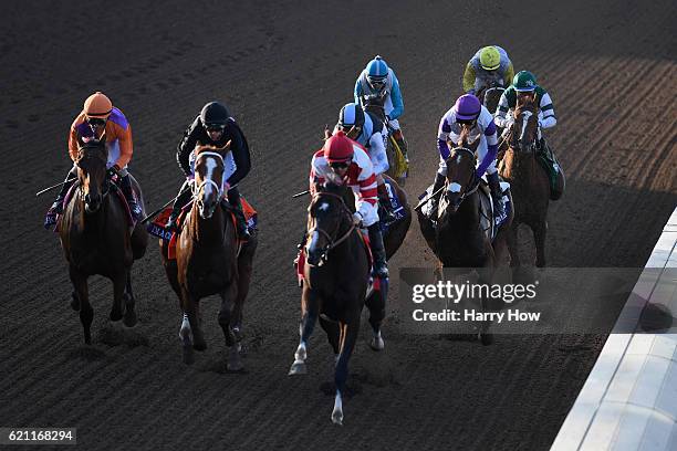 Jockey Gary Stevens aboard Beholder races alongside jockey Mike Smith aboard Songbird to the finish line in the Longines Breeders' Cup Distaff during...