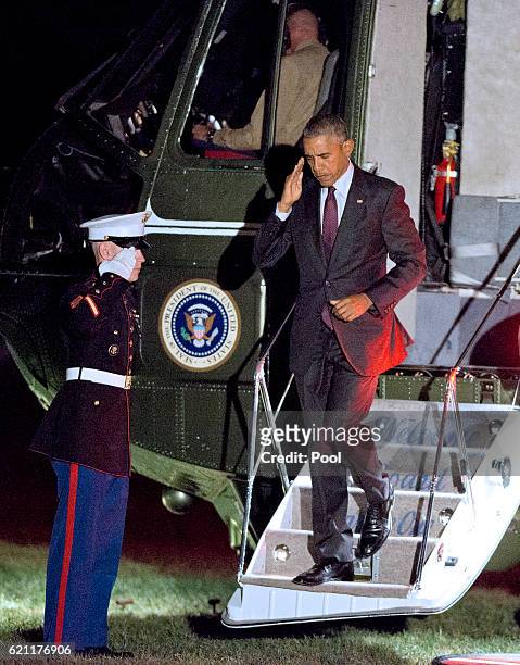 President Barack Obama salutes the Marine Guard as he arrives at the White House November 4, 2016 in Washington, DC. Obama is making campaign stops...