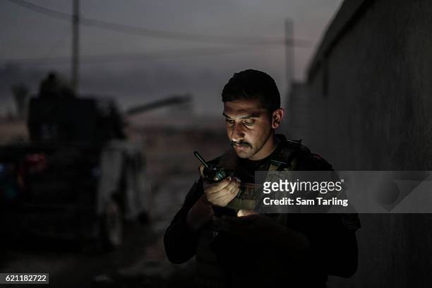 An Iraqi Special Forces Lieutenant speaks on his radio as his unit advances through the neighborhood of Tahrir and Zahara, formerly named after...