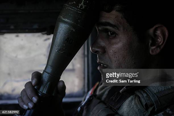 Sergeant Majid holds a rocket propelled grenade as his Humvee approaches the neighborhood of Tahrir and Zahara, formerly named after Saddam Hussein,...