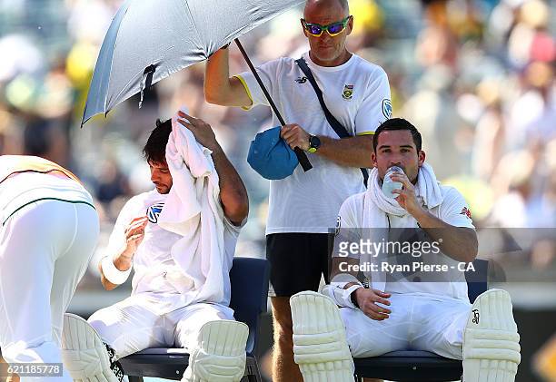 Jean-Paul Duminy and Dean Elgar of South Africa cool off during a drinks break during day three of the First Test match between Australia and South...