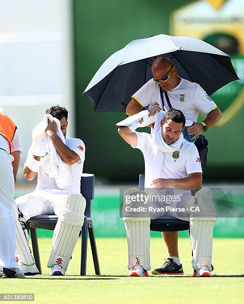 Jean-Paul Duminy and Dean Elgar of South Africa cool off during a drinks break during day three of the First Test match between Australia and South...