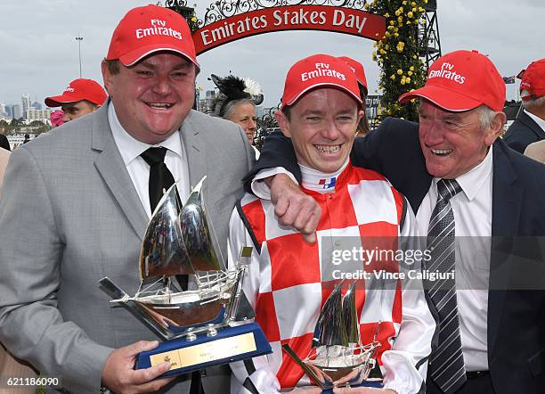 Stephen Baster poses with trainers Troy Corstens and Leon Corstens during trophy presentation after Awesome Rock won Race 7, Emirates Stakes on...