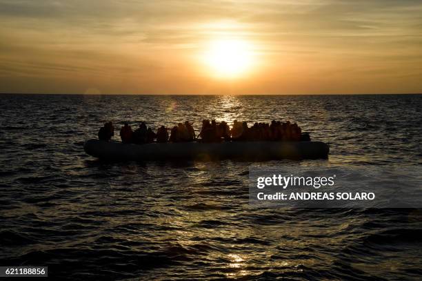Migrants and refugees sit on a rubber boat before to be rescued by the ship Topaz Responder run by Maltese NGO Moas and Italian Red Cross off the...