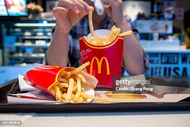 Girl eats fried chips in a McDonald's restaurant.