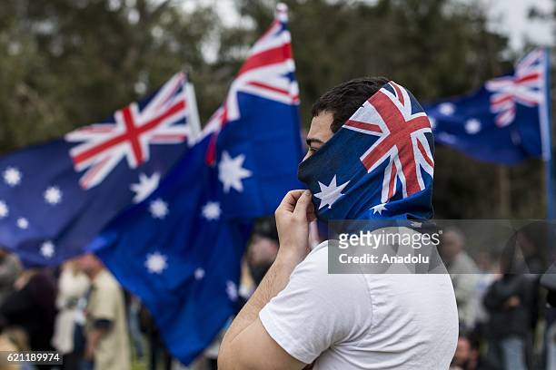 An anti-refugee protester poses with Australian flag mask during pro and anti refugee rallies in Eltham, Melbourne, Australia on November 05, 2016....