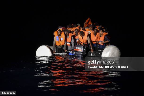 Migrants and refugees wait for further assistance during a rescue operation by the Topaz Responder ship, run by the Maltese NGO Moas and the Italian...
