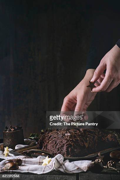 decorating of christmas chocolate yule log - buche noel stock pictures, royalty-free photos & images