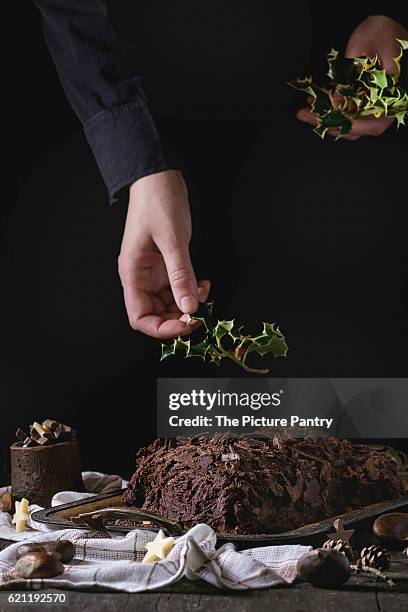 decorating of christmas chocolate yule log - yule log stock pictures, royalty-free photos & images