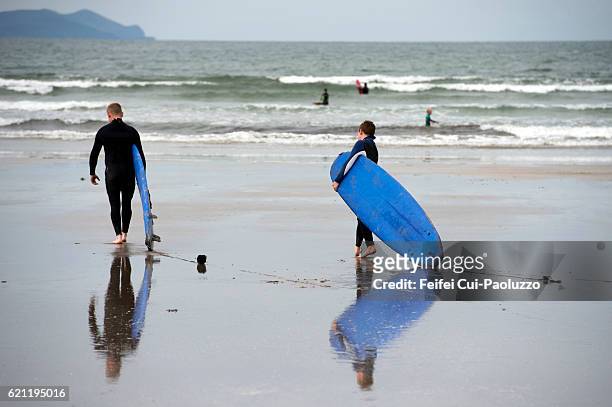 surfing at inch beach of kerry county in ireland - inch stock pictures, royalty-free photos & images