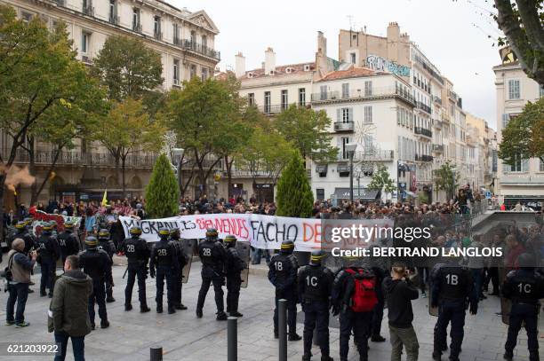 Pro-refugees demonstrators stand in front of riot police as they shout against French far-right Front National 's supporters in Marseille, southern...