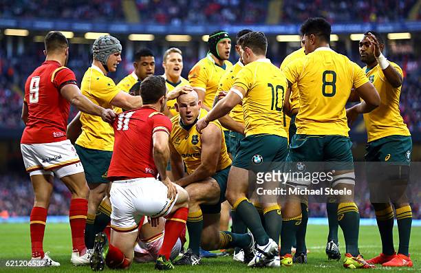 Stephen Moore of Australia is congratulated by teammates after scoring the opening try during the international match between Wales and Australia at...
