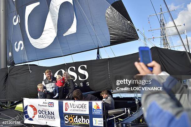 British skipper Alex Thomson poses with his family aboard his class Imoca monohull "Hugo Boss" on November 5, 2016 in Les Sables-d'Olonne, western...