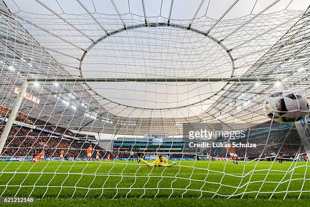 Hakan Calhanoglu of Leverkusen shoot the first goal against Goalkeeper Michael Esser of Darmstadt during the Bundesliga match between Bayer 04...