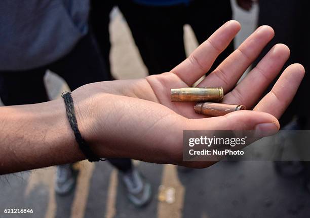 Kashmiri Muslim show empty bullet catridges allegedly used by the Indian government forces on the mourners during the funeral of Qaisar Sofi, a 16...