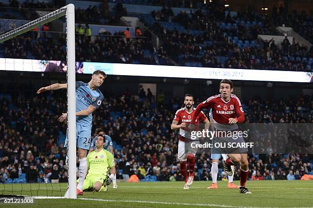 Manchester City's Chilean goalkeeper Claudio Bravo and Manchester City's English defender John Stones react as Middlesbrough's Dutch midfielder...