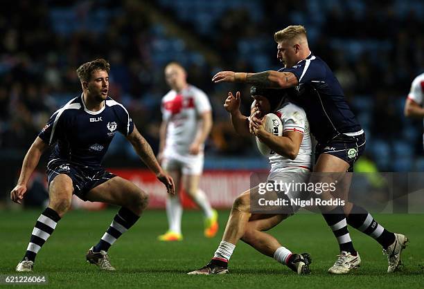 Jonny Lomax of England takcled by Danny Addy of Scotland during the Four Nations match between the England and Scotland at The Ricoh Arena on...