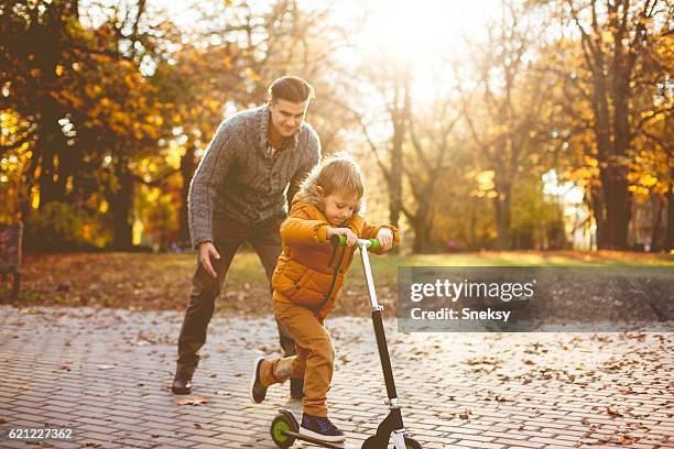 junge lernen, wie man roller fahren - kinder kickboard stock-fotos und bilder