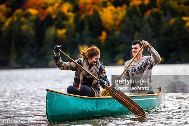 paar genießt eine fahrt auf einem typischen kanu in kanada - canoe stock-fotos und bilder