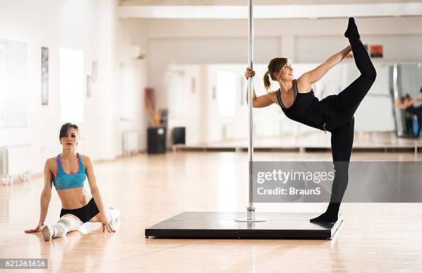 young pole dancers warming up in a dance studio. - pole dance stock pictures, royalty-free photos & images