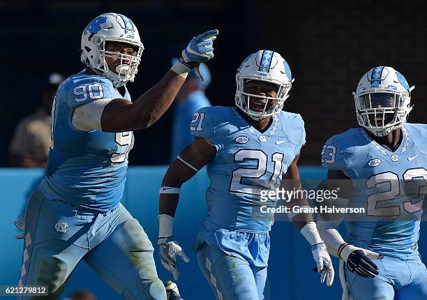 Nazair Jones, Myles Dorn and Cayson Collins of the North Carolina Tar Heels celebreate after a fourth down stop against the Georgia Tech Yellow...