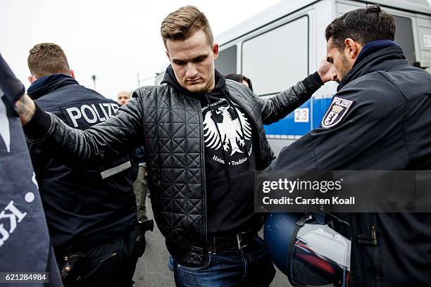 Policeman checks the pockets of new arrivals as right-wing activists gather in front of Hauptbahnhof main railway station before marching through the...