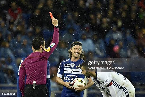 Bastia's French midfielder Yannick Cahuzac receives a red card from French referee Franck Schneider during the French L1 football match Olympique...
