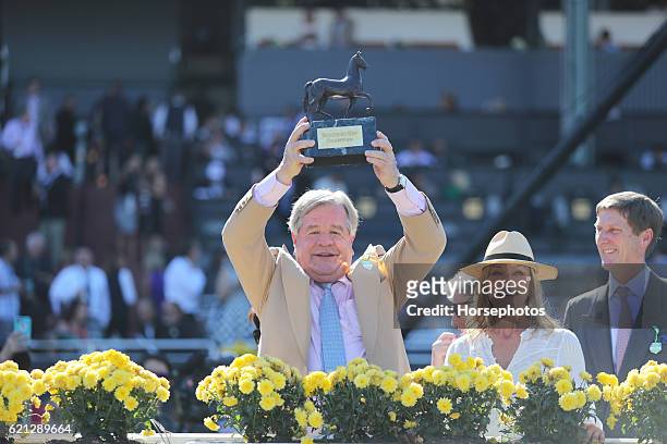 Trainer Michael Stoute raises trophy after Queen's Trust with Lanfranco Dettori wins the Breeders' Cup Filly & Mare Turf during day two of the 2016...