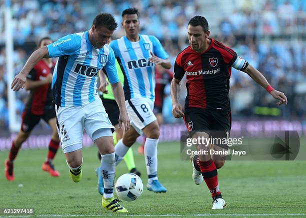 Ivan Pillud, of Racing Club, and Maxi Rodriguez, of Newell's Old Boys, fight for the ball during a match between Racing Club and Newell's Old Boys as...