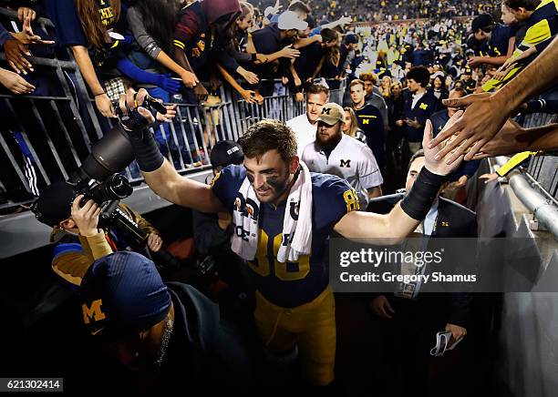 Jake Butt of the Michigan Wolverines celebrates a 59-3 win over the Maryland Terrapins with fans on November 5, 2016 at Michigan Stadium in Ann...